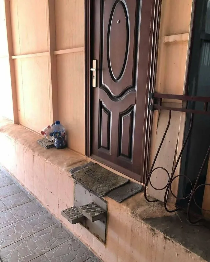Small metal steps installed leading up to a raised door, showing creative Slavic engineering.