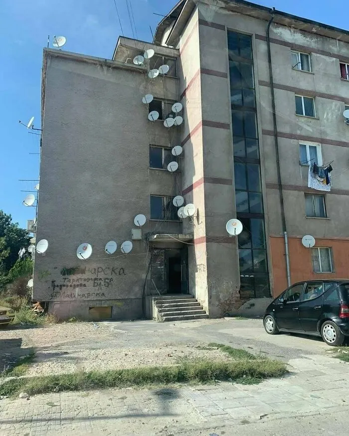 Slavic engineering display of dozens of satellite dishes on an apartment building