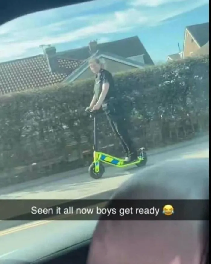 UK police officer riding a high-visibility electric scooter on a residential street