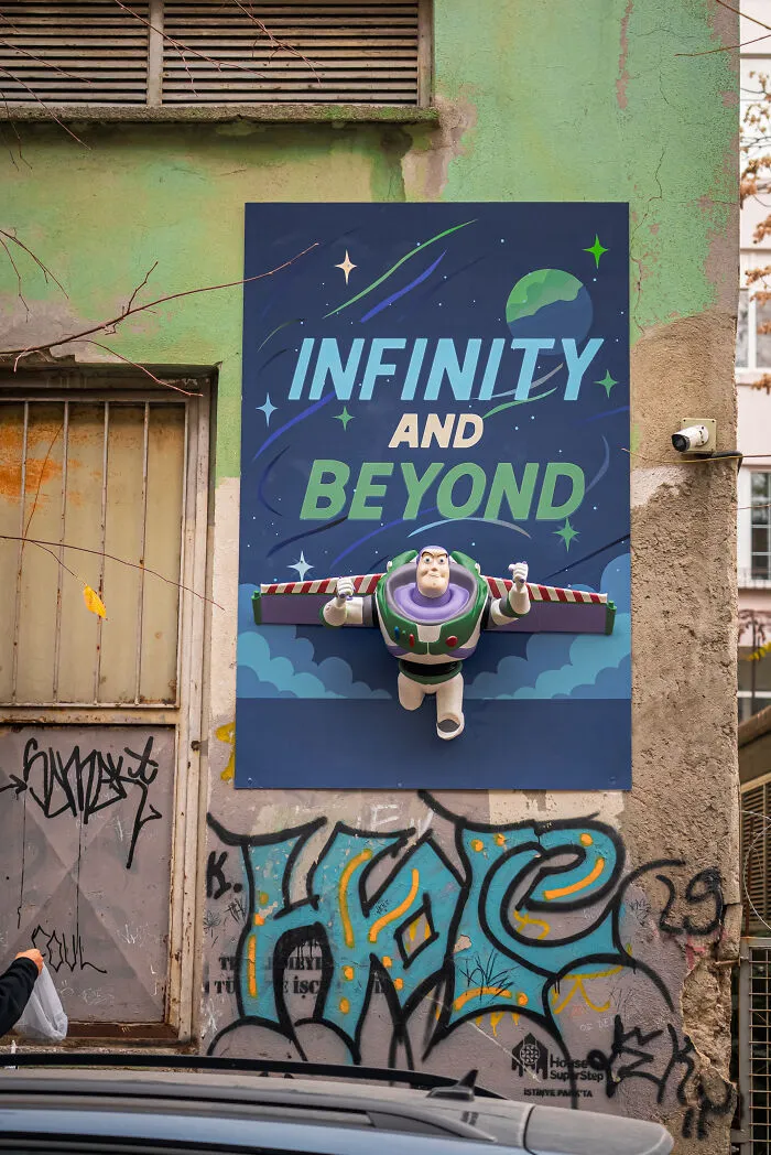 A Buzz Lightyear poster on city streets showcasing creative art collective graffiti style.