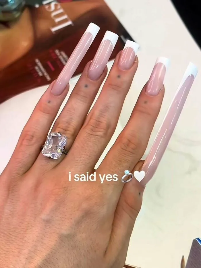Hand with overly long nails and large ring in cursed images