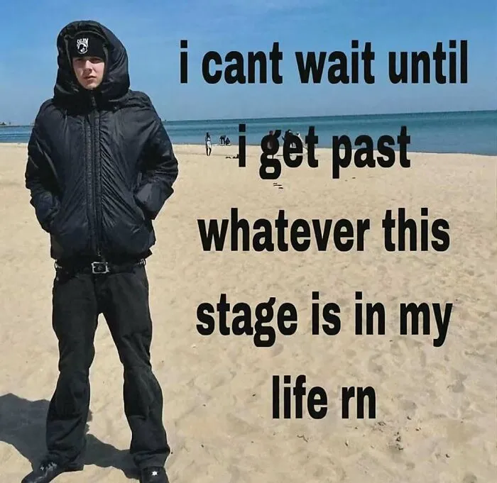 A person wearing a heavy black winter jacket on a sunny beach in a meme about awkward life stages.