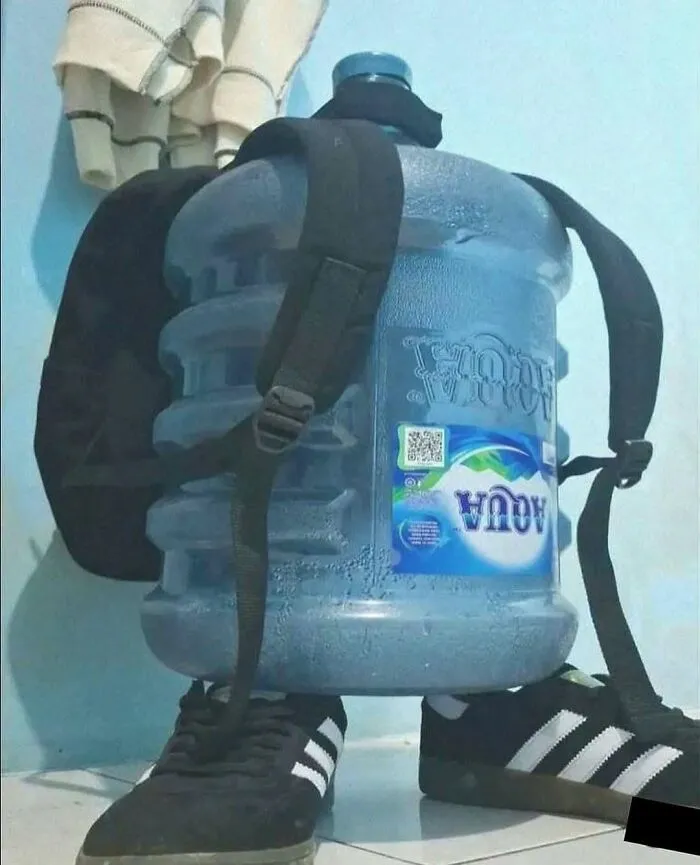 A large water jug wearing a backpack and shoes, making for amusing posts.