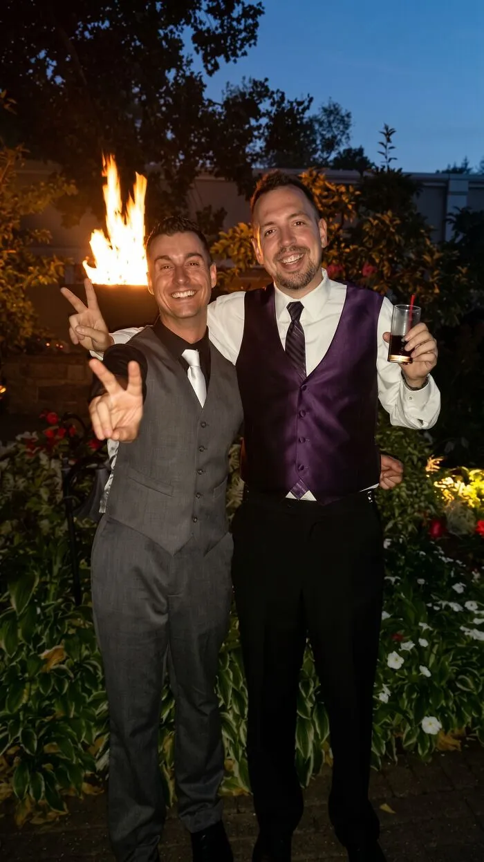 Two men in suits smiling and posing at an evening event