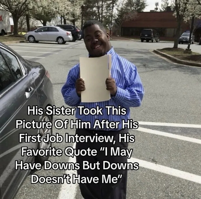 A smiling man holding a folder in a parking lot, representing wholesome moments.