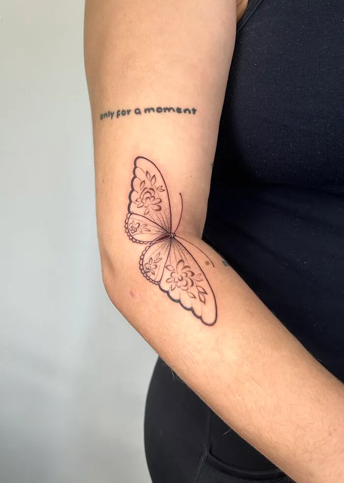 Delicate floral outline butterfly tattoo on inner arm