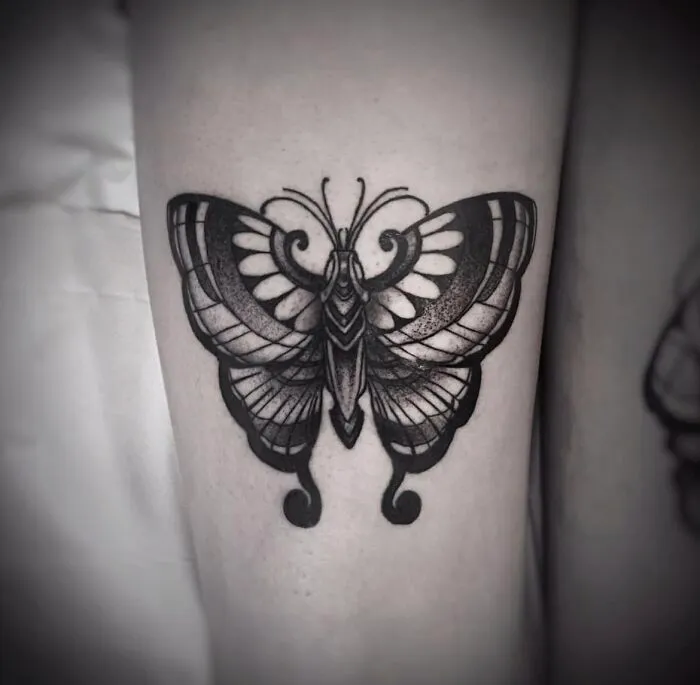 Detailed black and gray butterfly tattoo on arm