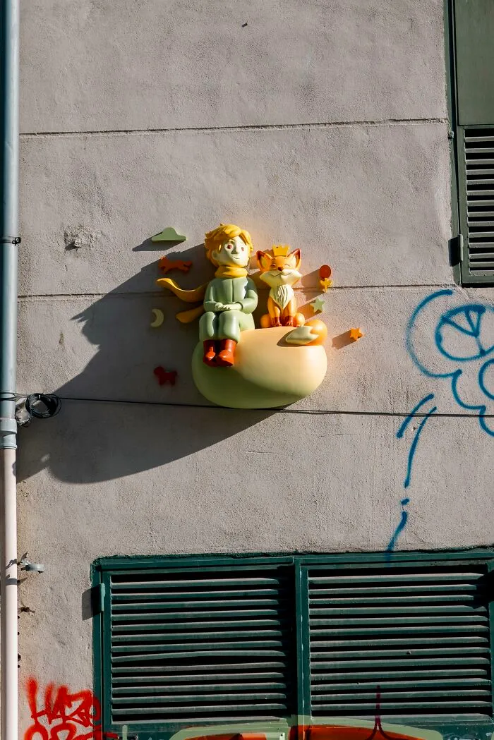The Little Prince and Fox 3D sculpture on a concrete wall on city streets