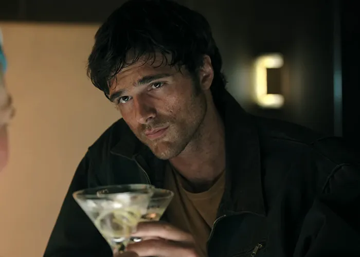 Actor holding a martini glass representing Hollywood stars in a dramatic movie scene.