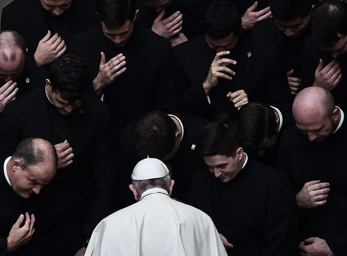 Group of men in black with leader in white, somber moment, best pics Siena International Photo Awards 2026