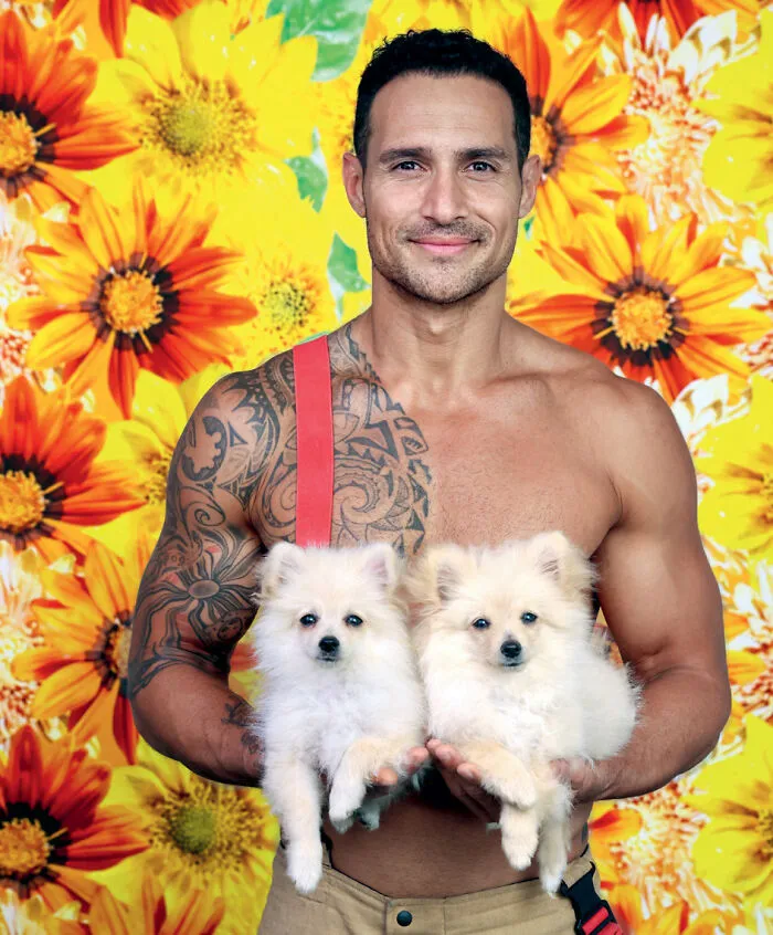 2027 Australian firefighters calendar man with tattoo holding two small dogs with sunflower backdrop