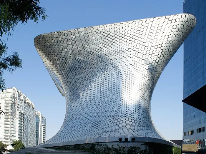 Modern buildings with bizarre shapes featuring a curved metallic textured facade