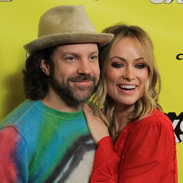 Hollywood actress Olivia Wilde holding a yellow envelope on stage