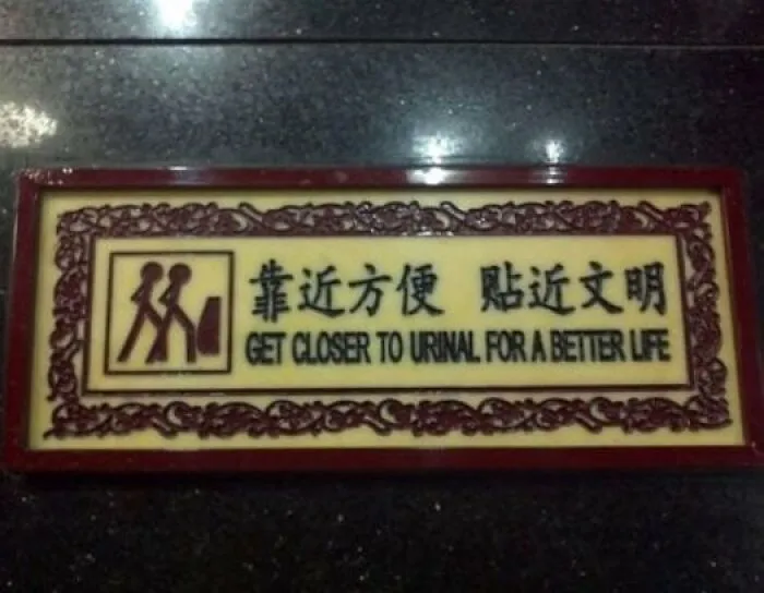 Restroom sign example of translation fails reading get closer to urinal for a better life