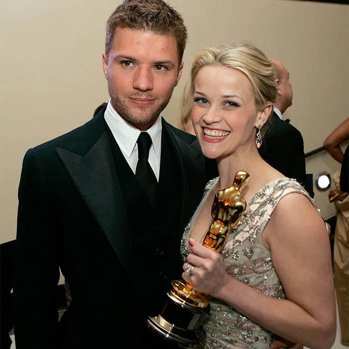 Hollywood actress Reese Witherspoon posing in a black and gold dress