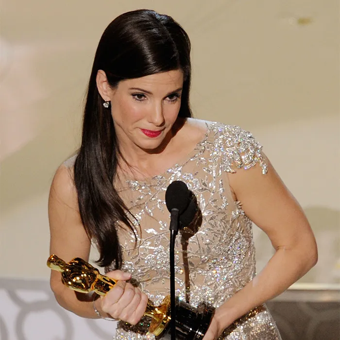 Hollywood actress Sandra Bullock holding her Oscar trophy on stage
