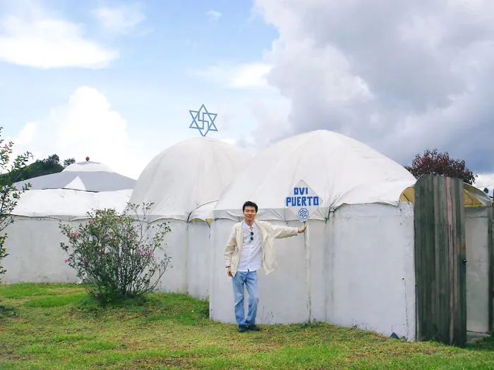 A man standing outside dome-shaped buildings associated with Raëlism, one of many lesser-known cults.