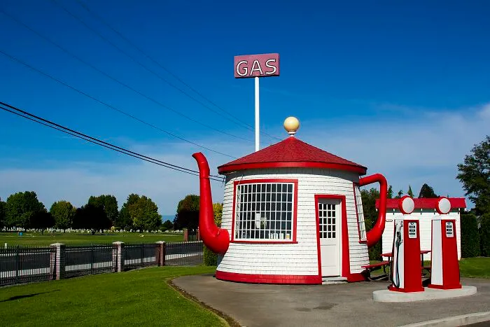 A teapot-shaped gas station showing bizarre architecture.