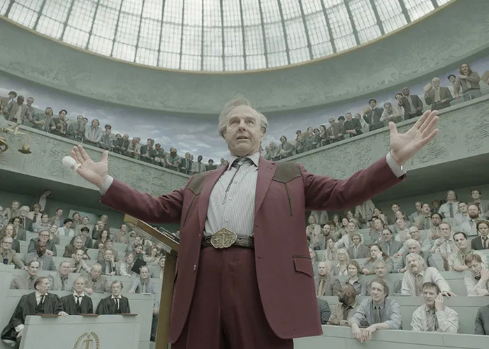 Hollywood stars in a movie scene addressing a large courtroom audience in a grand auditorium setting.
