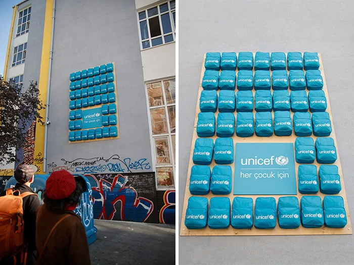 Blue UNICEF backpacks installed on a wall as creative art collective street art.