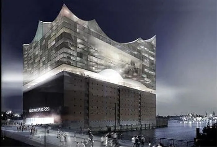 Modern architectural building with illuminated wavy glass exterior at night