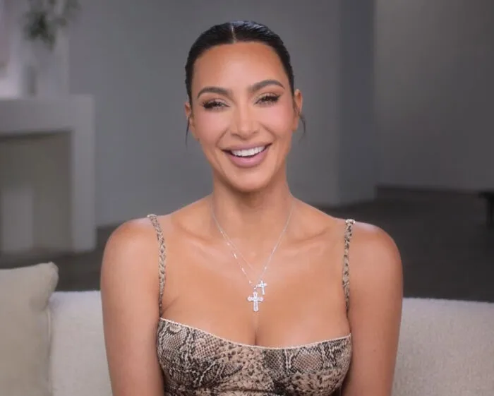 Kim Kardashian smiling in a snake-print dress, representing famous figures involved in huge PR stunts.