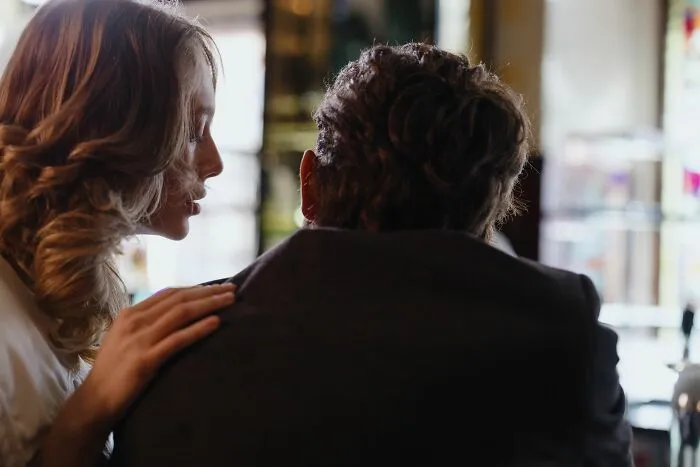 Woman whispering to a man, ready to share the tea