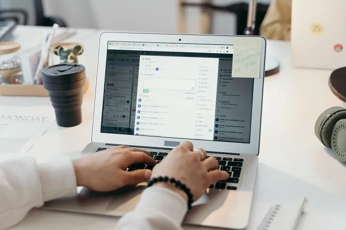 Hands typing on a laptop with data on screen, uncovering secrets