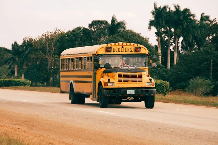 Yellow school bus on the road carrying people who found secrets