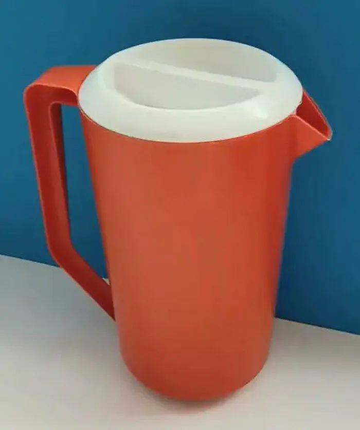 Classic orange plastic Tupperware pitcher, a staple nostalgic photo from '80s kids childhoods.