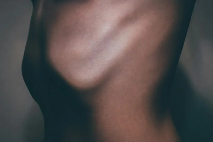 A close-up shot of a person's ribcage and midsection, illustrating misconceptions about women's bodies.