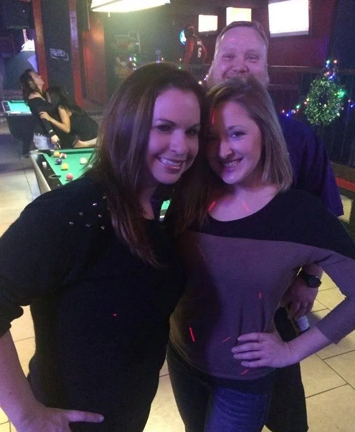 An unexpected guest hijacks a photo of two friends with a humorous background photobomb.