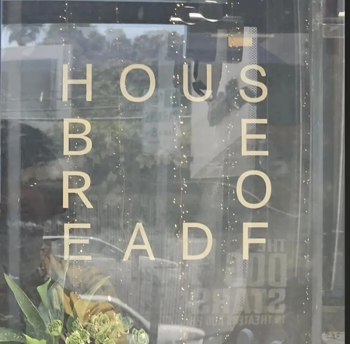 Window sign with jumbled text creating a confusing design choice