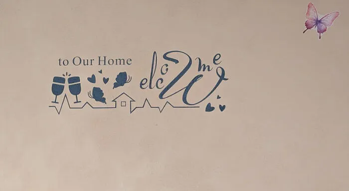 Wall decal with jumbled welcome home message and butterfly