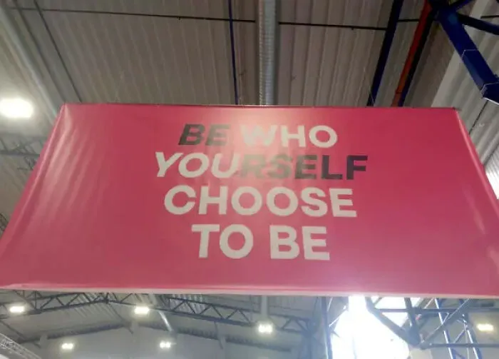 Faded motivational sign with unclear text about being yourself