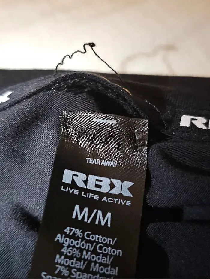 Clothing tag with loose thread causing discomfort design flaw