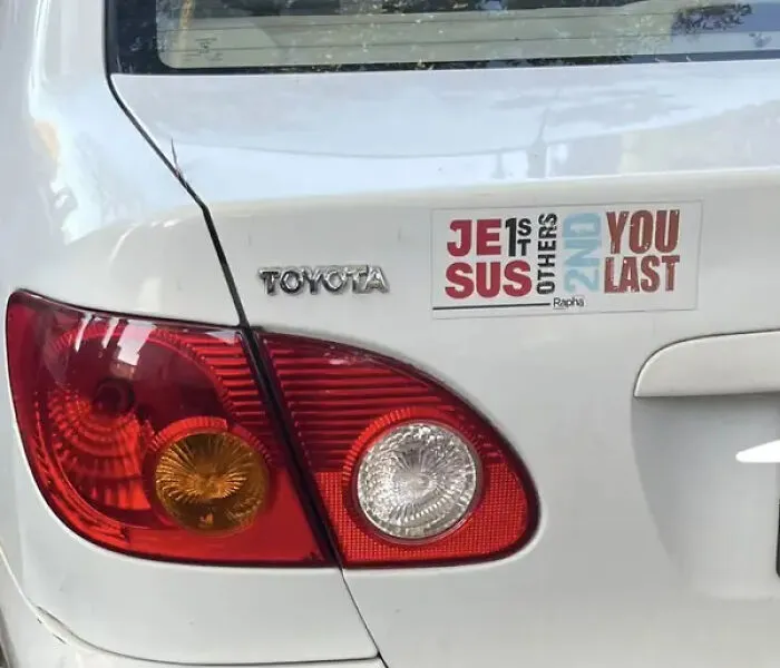 Car rear with sticker showing Jesus first others second and you last design choices