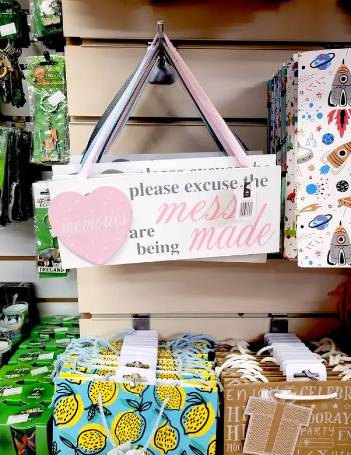 Memories sign with pink heart stating please excuse the mess design choices store display