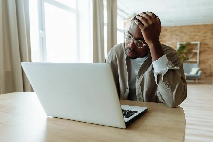 Stressed man using laptop at home highlighting essential life skills