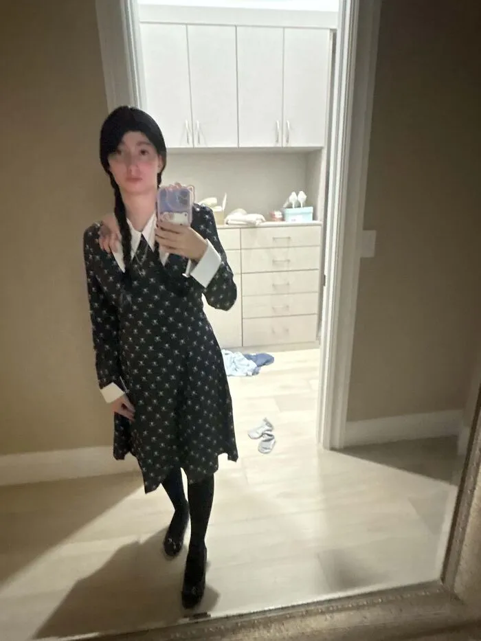 Person taking a selfie dressed up in a Wednesday Addams Halloween costume.