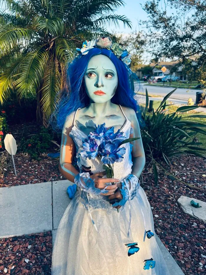 Woman in corpse bride Halloween costume with blue body paint and blue hair