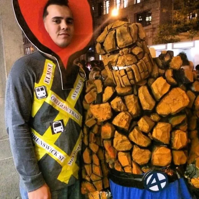 Two men wearing unique Halloween costumes posing as a map pin and superhero character outdoors