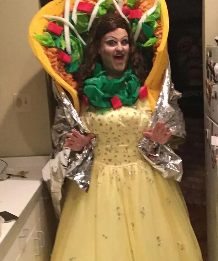 Person dressed in a hilarious Taco Belle mashup Halloween costume combining a taco and a yellow gown.