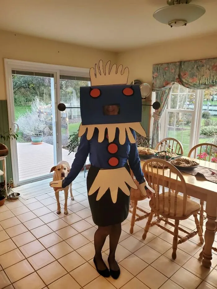 Person wearing a handmade Rosie the Robot costume as creative Halloween costumes inside a kitchen.