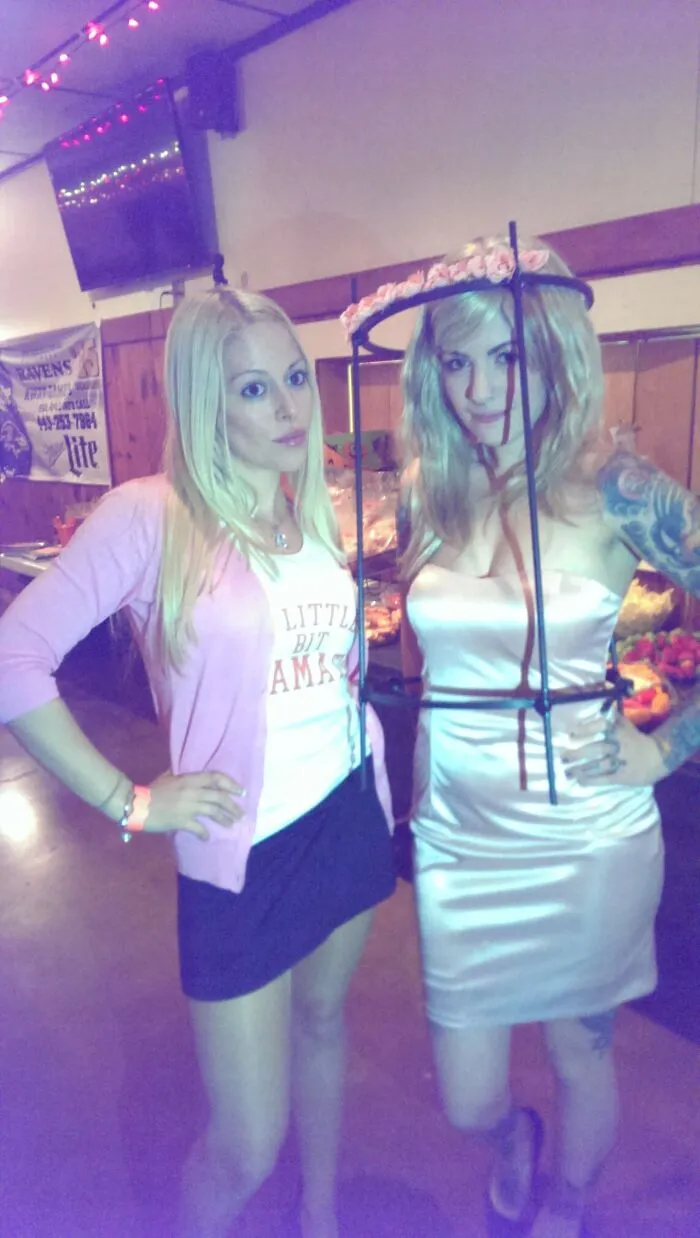 Two women dressed up for Halloween, one wearing a halo rig, showing off unique Halloween costumes