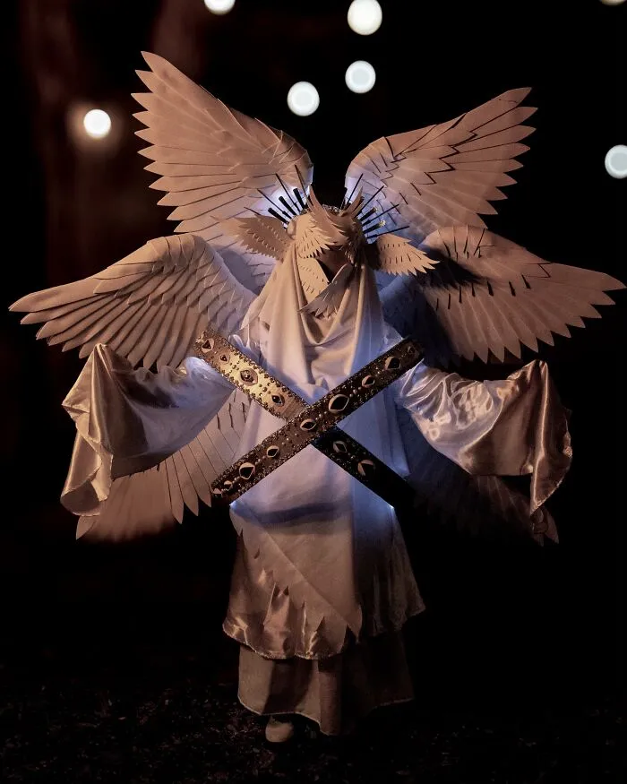 Detailed seraphim angel elaborate Halloween costumes with large white feathered wings and golden accents.