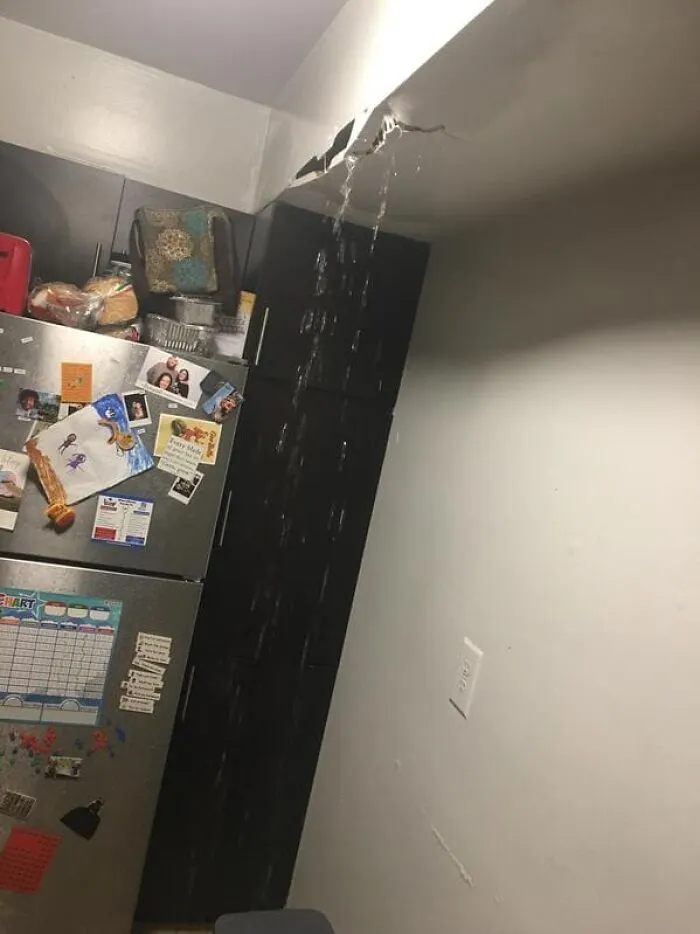 Water leaking from a cracked kitchen ceiling, illustrating terrible roommate stories.