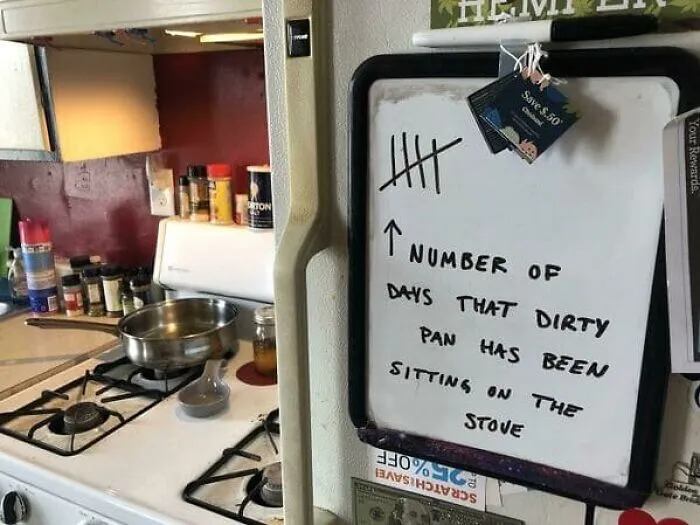 A whiteboard tallying days a dirty pan was left on the stove, highlighting relatable roommate stories.