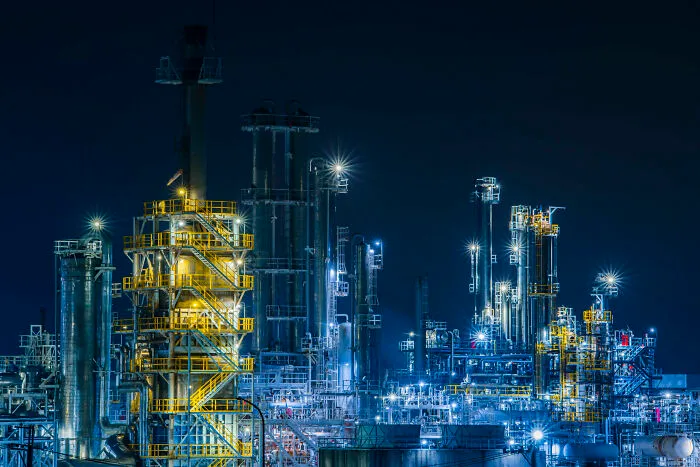 Night view of an illuminated industrial refinery, highlighting the beauty of buildings and spaces.
