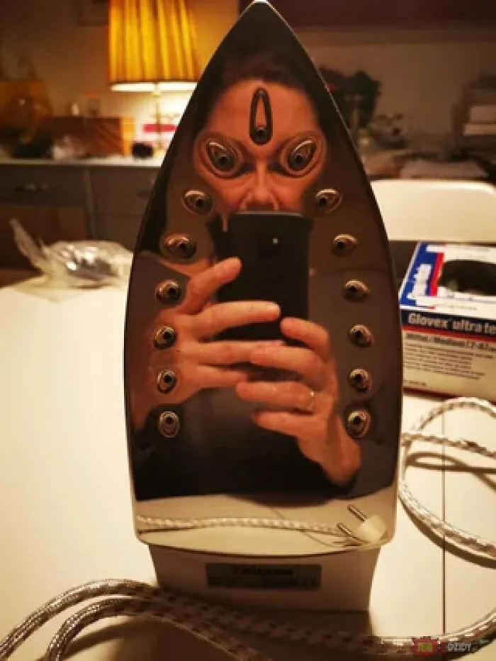 Alien like face reflected in a shiny clothes iron in funny mirror pics